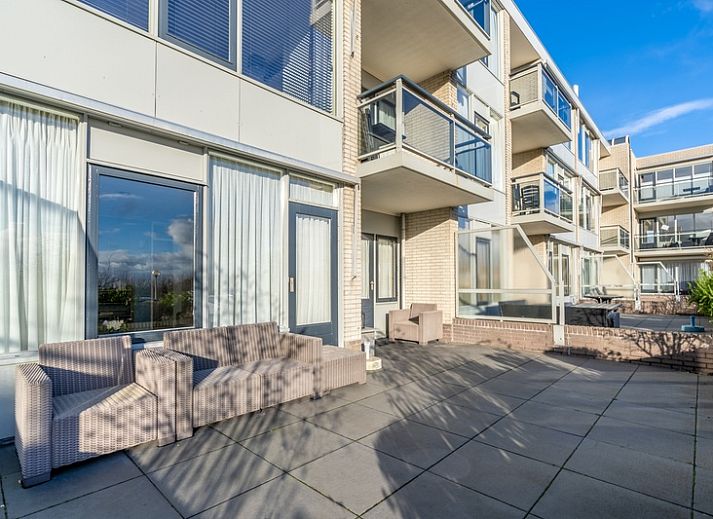 Lichte leefruimte van Appartement Juliana 076 Eilandzicht in De Koog, Texel met comfortabele zithoek en buitenzicht.