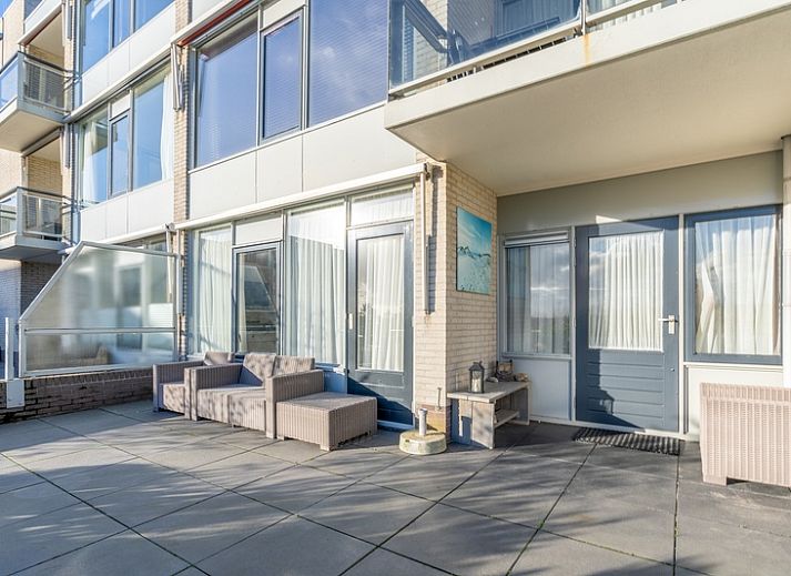 Lichte leefruimte van Appartement Juliana 076 Eilandzicht in De Koog, Texel met comfortabele zithoek en buitenzicht.