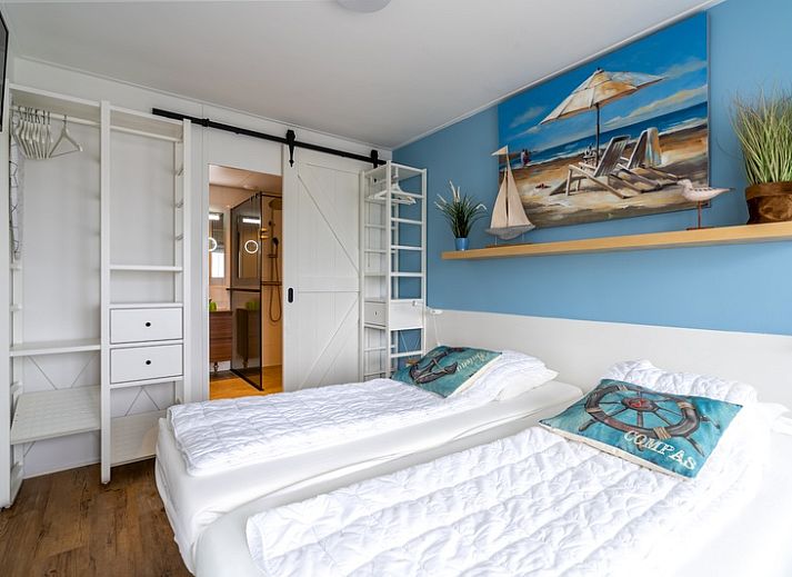 Lichte leefruimte van Appartement Juliana 076 Eilandzicht in De Koog, Texel met comfortabele zithoek en buitenzicht.