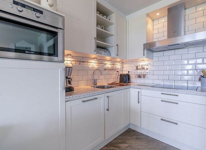 Lichte zithoek in Appartement Juliana 106 Zeezicht in De Koog, Texel met comfortabele banken en zeezicht.