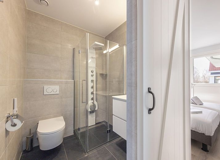 Stilvolles Wohnzimmer in Villa 8, einem Ferienhaus in De Koog, Texel. Gemuetliche Sitzecke mit Holzofen und Blick auf die Natur.