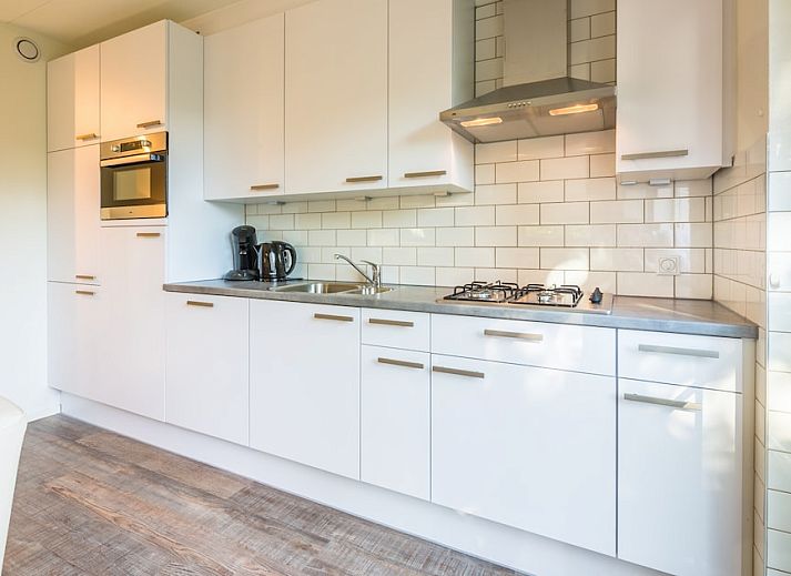 T6A Comfort bungalow in De Koog, Texel met zonnig terras en ligstoelen in groene omgeving.