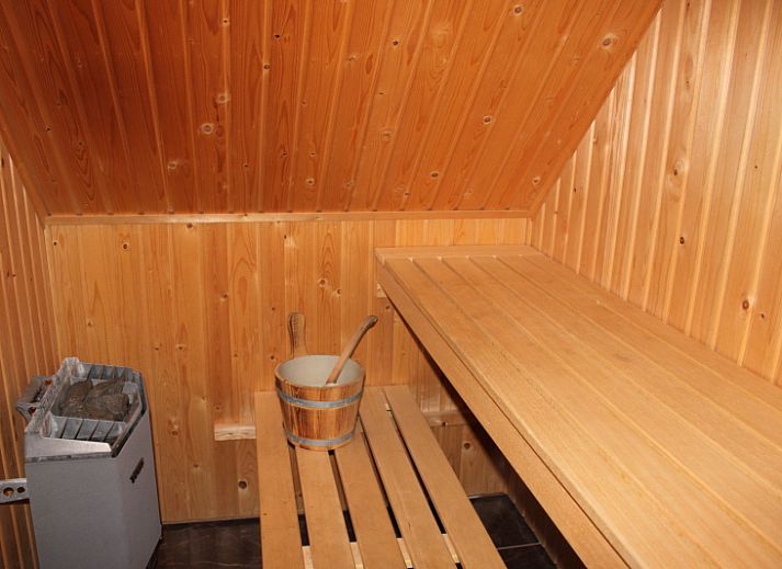 Gezellige woonkamer van Villa 4 personen in De Koog Texel, met comfortabele stoelen en kleurrijke kunst aan de muur.