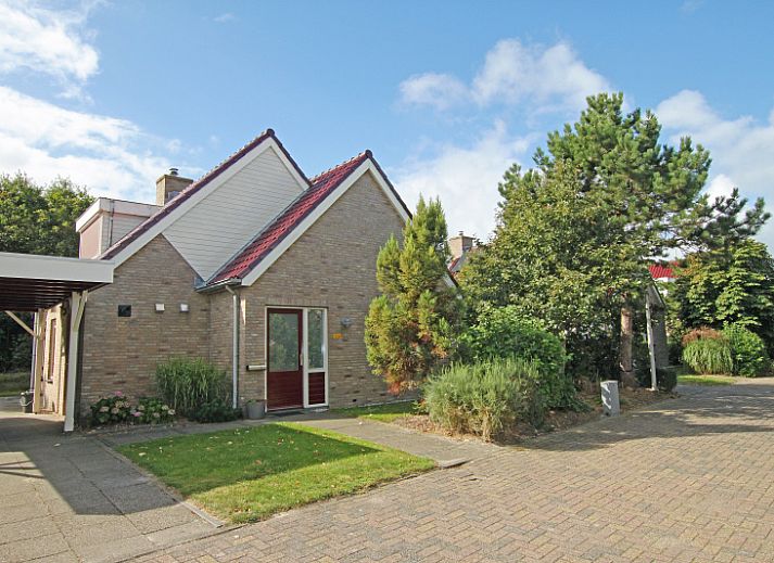 Gezellige woonkamer van Villa 4 personen in De Koog Texel, met comfortabele stoelen en kleurrijke kunst aan de muur.