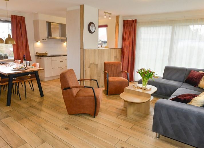 Rustiek vakantieverblijf De Eik op Texel omgeven door groene duinen en bomen.