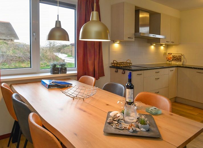 Rustiek vakantieverblijf De Eik op Texel omgeven door groene duinen en bomen.