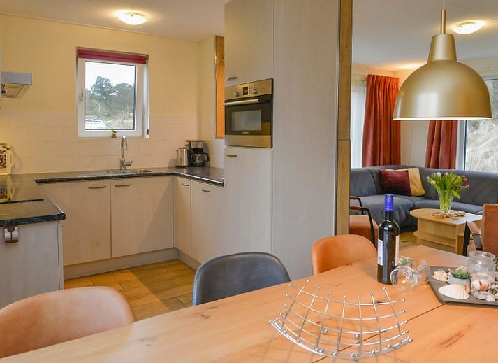 Rustiek vakantieverblijf De Eik op Texel omgeven door groene duinen en bomen.