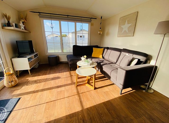 Chalet Bregkoog 255 in De Koog, Texel met houten omheining en zonnige buitenkant.