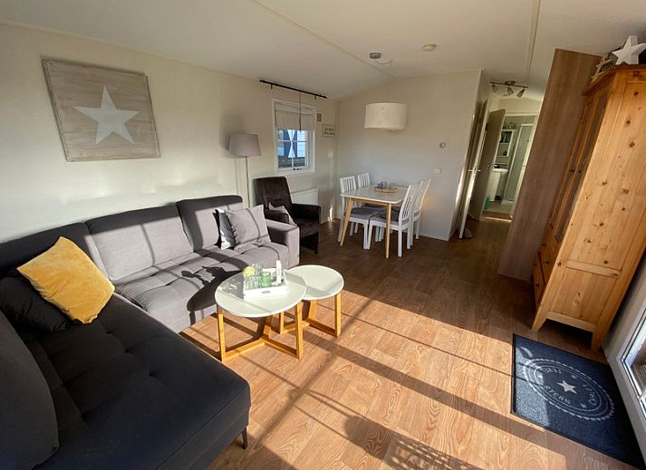 Chalet Bregkoog 255 in De Koog, Texel met houten omheining en zonnige buitenkant.