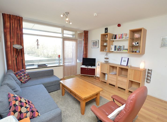Gezellige woonkamer in Appartement Kerckeland 50, De Koog, Texel met comfortabele zithoek en uitzicht op de natuur.