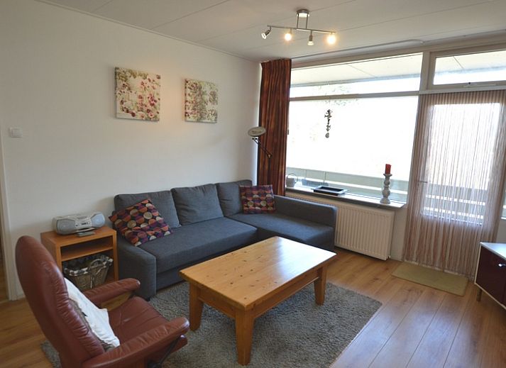 Gezellige woonkamer in Appartement Kerckeland 50, De Koog, Texel met comfortabele zithoek en uitzicht op de natuur.