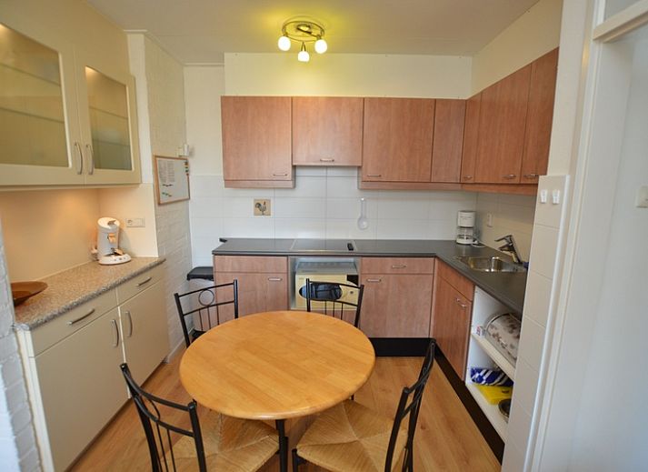 Lichte woonkamer in Appartement Kerckeland 50, De Koog, Texel met ruime bank en decoratieve elementen.