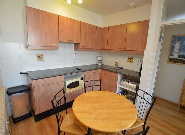 Lichte woonkamer in Appartement Kerckeland 50, De Koog, Texel met ruime bank en decoratieve elementen.