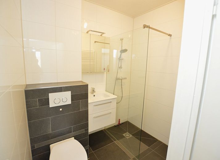 Lichte woonkamer in Appartement Kerckeland 50, De Koog, Texel met ruime bank en decoratieve elementen.