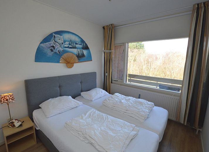 Lichte woonkamer in Appartement Kerckeland 50, De Koog, Texel met ruime bank en decoratieve elementen.