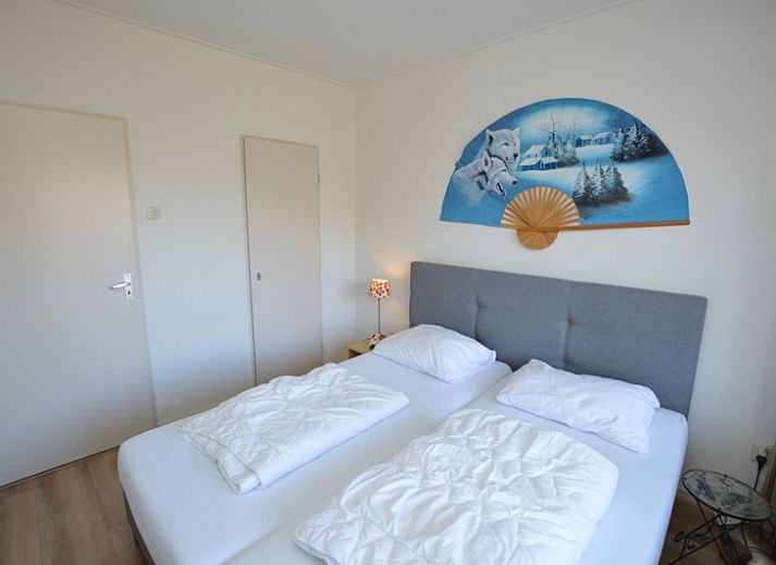 Moderne woonkamer van Appartement Kerckeland 50, De Koog, Texel met uitnodigende zithoek en boekenplanken.