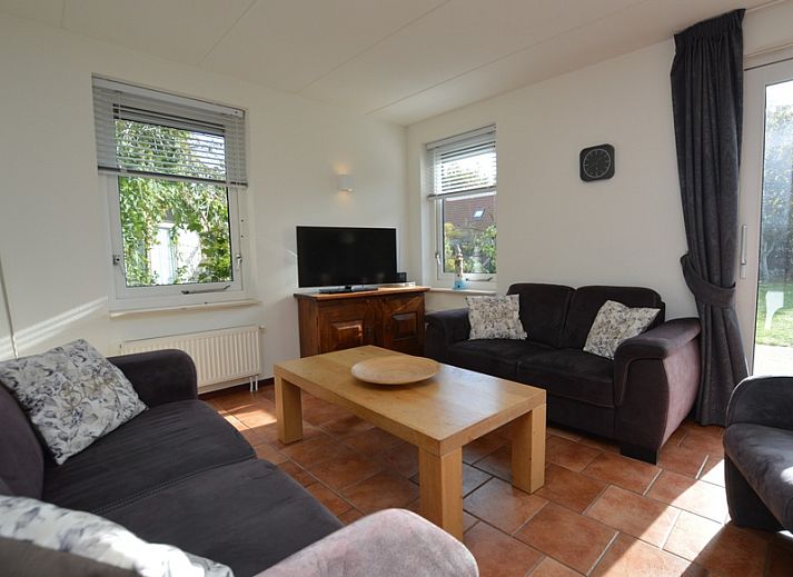 Das Ferienhaus 7G in De Koog, Texel, hat ein schoenes Aeusseres mit einem roten Dach und einer gruenen Umgebung.