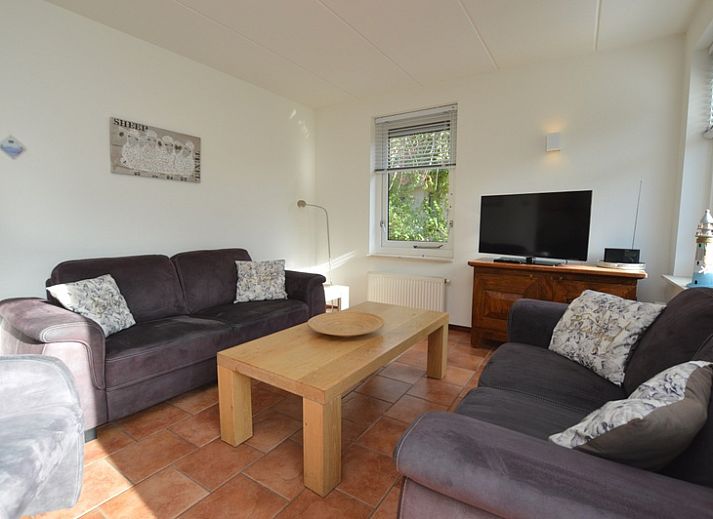 Das Ferienhaus 7G in De Koog, Texel, hat ein schoenes Aeusseres mit einem roten Dach und einer gruenen Umgebung.