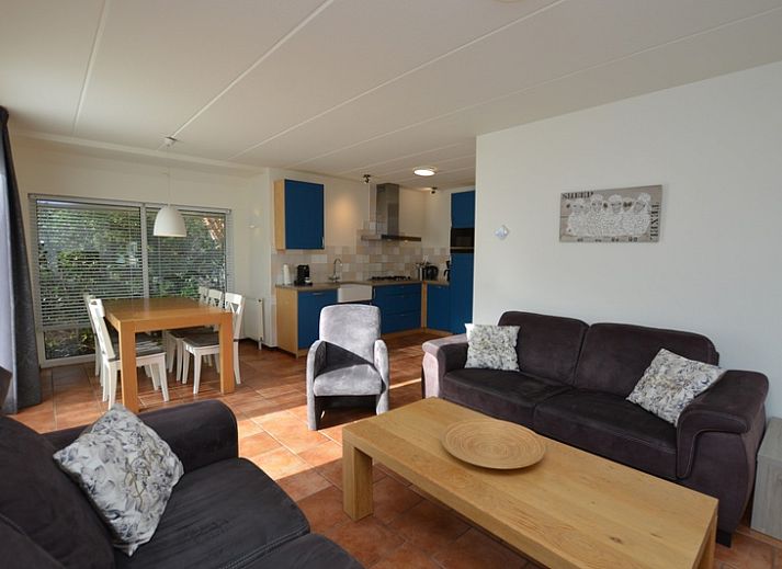 Das Ferienhaus 7G in De Koog, Texel, hat ein schoenes Aeusseres mit einem roten Dach und einer gruenen Umgebung.