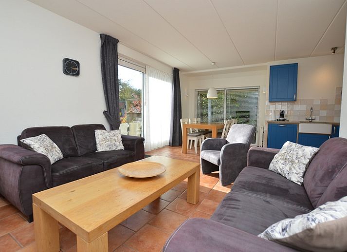 Das Ferienhaus 7G in De Koog, Texel, hat ein schoenes Aeusseres mit einem roten Dach und einer gruenen Umgebung.