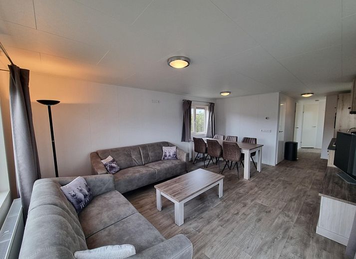 Spacious living room in Chaletpark Bregkoog - Chalet 240 De Texelse Berg, De Koog, Texel with comfortable sitting area and dining area.