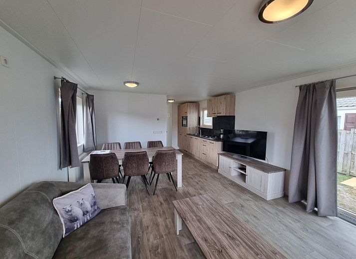 Spacious living room in Chaletpark Bregkoog - Chalet 240 De Texelse Berg, De Koog, Texel with comfortable sitting area and dining area.