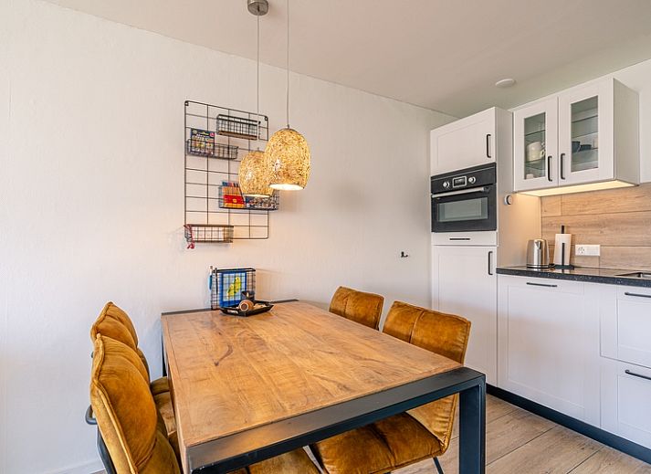 Stijlvolle zithoek in Appartement Anna 220, De Koog, Texel met comfortabele stoelen en een flatscreen-tv.