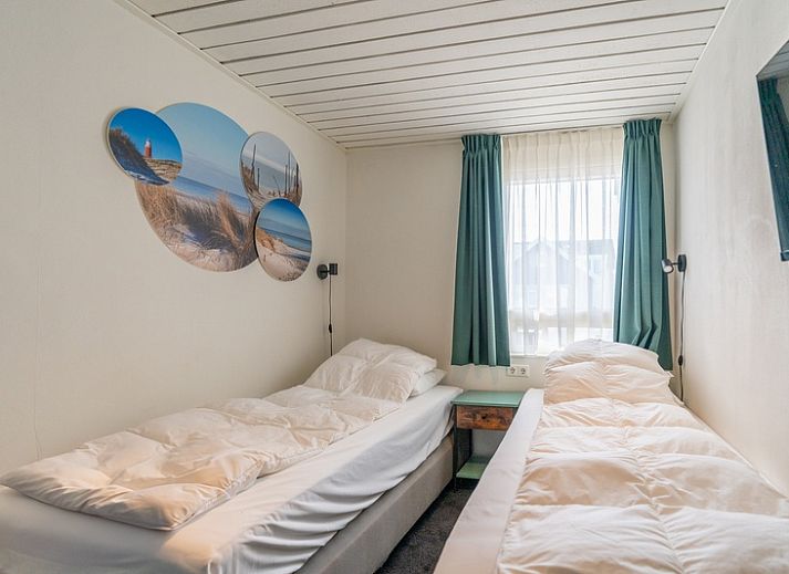 Stijlvolle zithoek in Appartement Anna 220, De Koog, Texel met comfortabele stoelen en een flatscreen-tv.