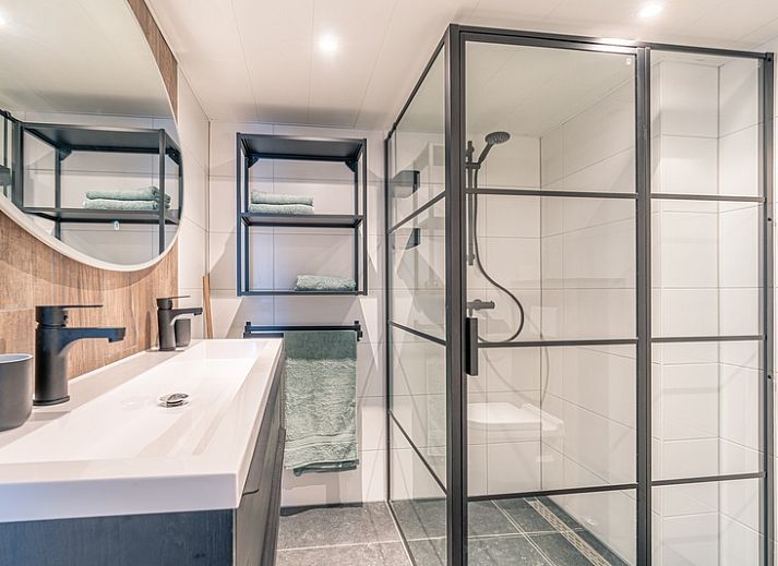 Stijlvolle zithoek in Appartement Anna 220, De Koog, Texel met comfortabele stoelen en een flatscreen-tv.