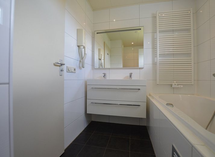 Ruime woonkamer in Vakantiehuis Stappeland 171, De Koog, Texel met comfortabele zithoek en veel lichtinval.