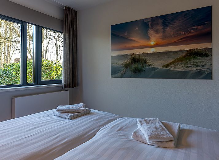 Zijaanzicht van vakantiehuis 16 - Zeebries in De Koog, Texel, omgeven door groen op de Waddeneilanden.