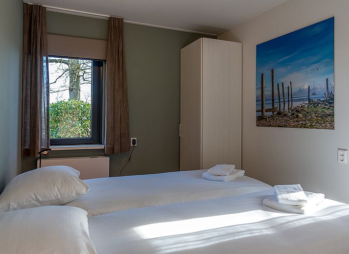 Zijaanzicht van vakantiehuis 16 - Zeebries in De Koog, Texel, omgeven door groen op de Waddeneilanden.