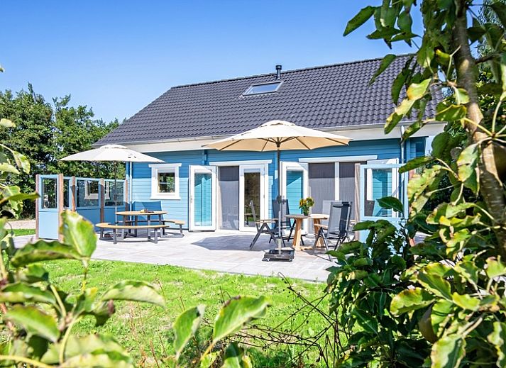 De Verleegen Hoek vakantiehuis in De Koog Texel, omringd door groene natuur en blauwe lucht.
