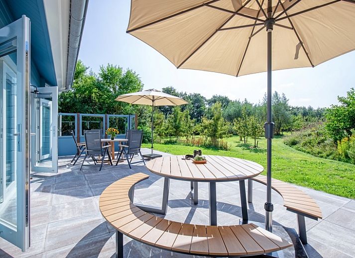 De Verleegen Hoek vakantiehuis in De Koog Texel, omringd door groene natuur en blauwe lucht.
