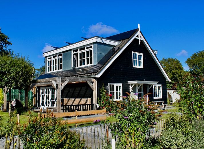 Residence Rustiek in De Koog, Texel, Ferienhaus mit charmanter Holzfassade und Garten