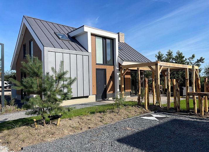 Duinvilla Wellness 6 in De Koog, Texel, ein modernes Ferienhaus mit Holzfassade und Veranda.