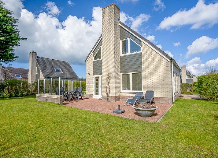 Aussenbereich des Ferienhauses Honeysuckle 91 mit Sauna, De Koog, Texel, mit sonniger Terrasse und gruenem Garten.