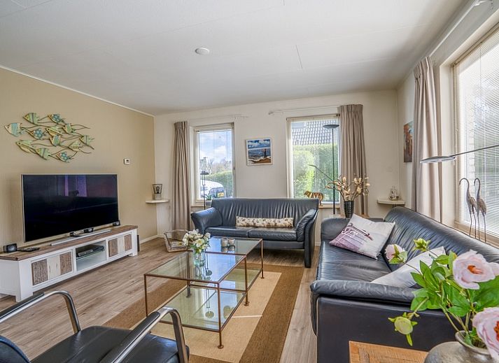 Aussenbereich des Ferienhauses Honeysuckle 91 mit Sauna, De Koog, Texel, mit sonniger Terrasse und gruenem Garten.