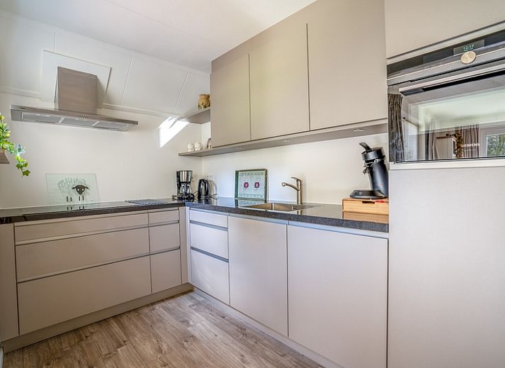 Gemuetliches Wohnzimmer im Ferienhaus Kamperfoelie 91, De Koog, Texel, mit bequemen Sofas und viel Licht.