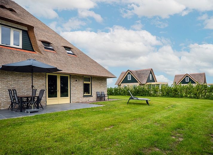 Vakantiehuis in De Koog, Texel met ruime tuin en comfortabele ligstoelen op het terras.