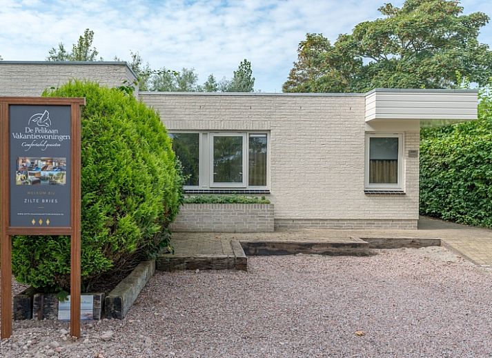 Zilte Bries vakantiehuis met terras in De Koog, Texel, omgeven door groene tuinen.