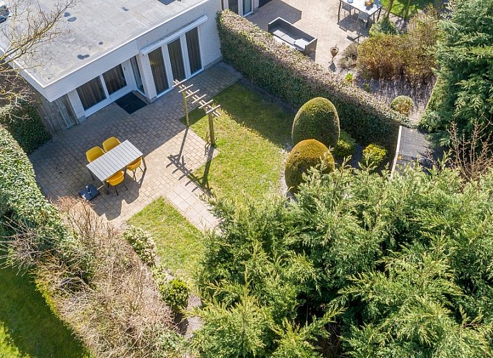 Zilte Bries vakantiehuis met terras in De Koog, Texel, omgeven door groene tuinen.