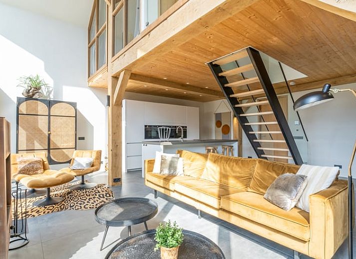 Gezellige woonkamer met open haard in Vakantiehuisje in De Koog, Texel, omringd door natuur.