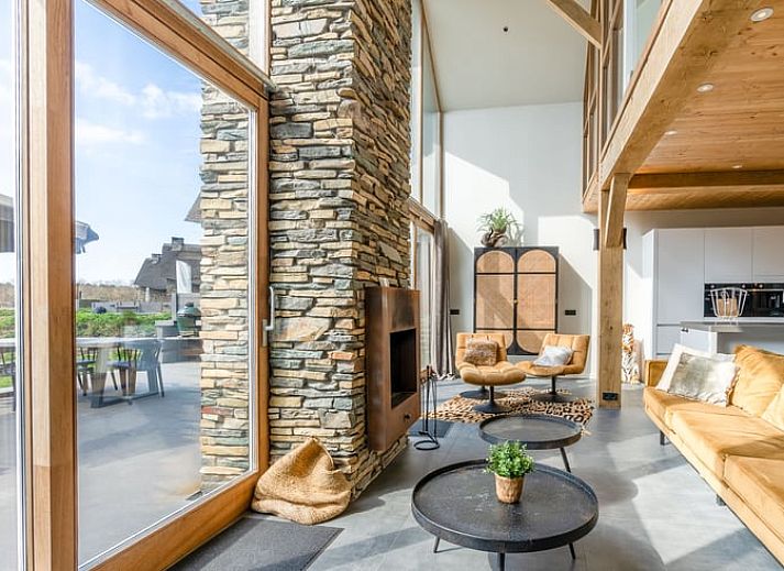 Gezellige woonkamer met open haard in Vakantiehuisje in De Koog, Texel, omringd door natuur.