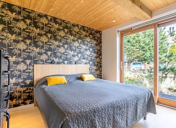 Gezellige woonkamer met open haard in Vakantiehuisje in De Koog, Texel, omringd door natuur.