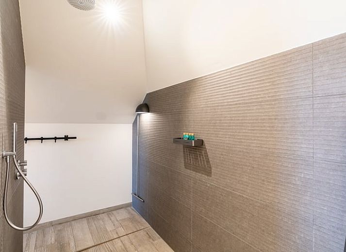 Comfortabele leeshoek met uitzicht op groene omgeving in Vakantiehuisje in De Koog, Texel.