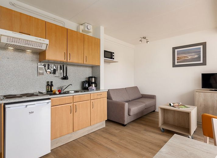 Helles Wohnzimmer von B Apartment Comfort 4 in De Koog, Texel, mit Blick auf die Natur und Zugang zur Terrasse.