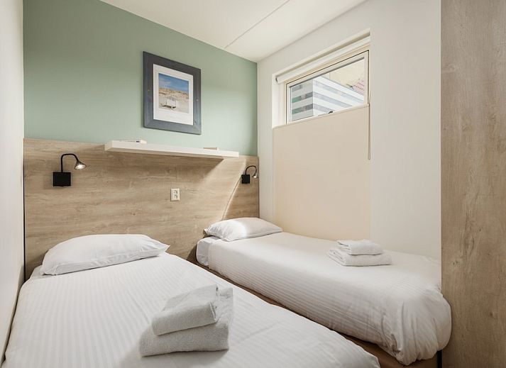 Helles Wohnzimmer von B Apartment Comfort 4 in De Koog, Texel, mit Blick auf die Natur und Zugang zur Terrasse.