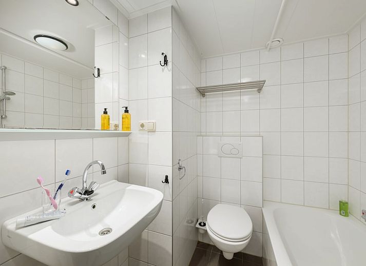 Helles Wohnzimmer von B Apartment Comfort 4 in De Koog, Texel, mit Blick auf die Natur und Zugang zur Terrasse.