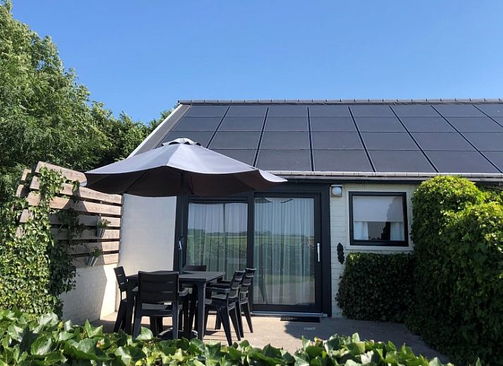 Bungalow 2 in De Koog, Texel met zonnig terras en tuinmeubilair, ideaal vakantiehuis op de Waddeneilanden.